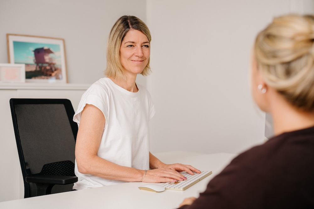 Ärztin im Beratungsgespräch mit Patientin am Schreibtisch – Neurologie und Psychiatrie Fürstenfeldbruck