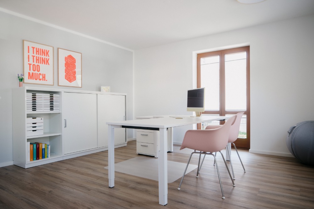 Helles Behandlungszimmer mit Schreibtisch und Regal